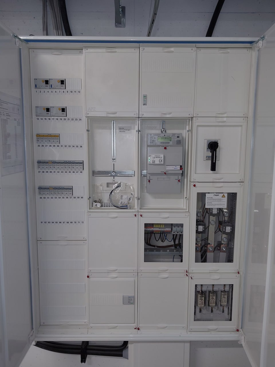 Geöffneter Zählerschrank mit Stromzähler und elektrischer Verteilung